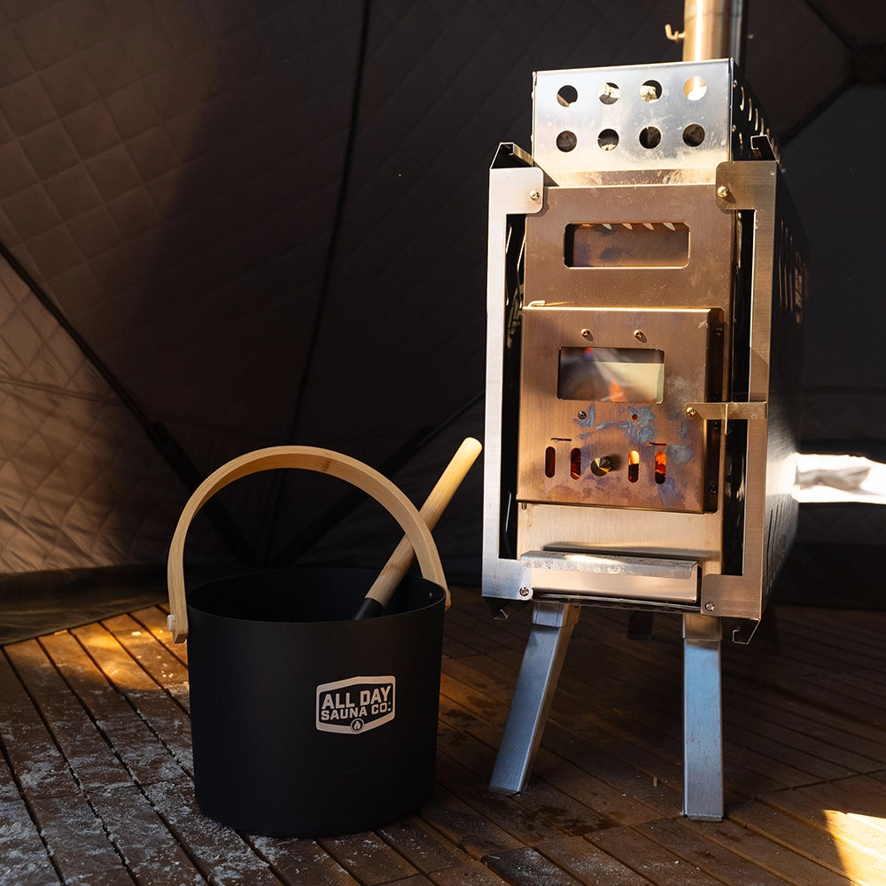 All Day Sauna Co. water bucket and ladle displayed with the sauna stove — part of complete sauna experience