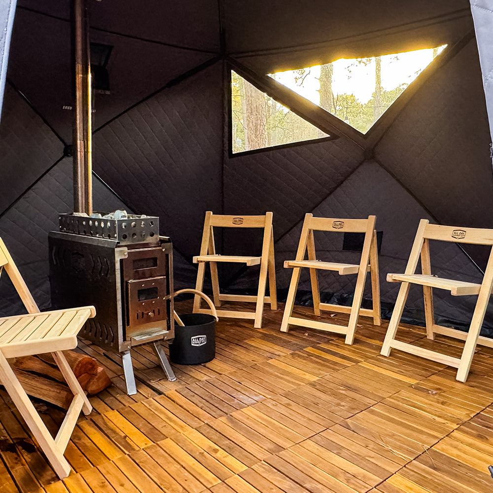 Interior of 6‑person outdoor sauna showing seating and sauna stove/heater setup by All Day Sauna Co.